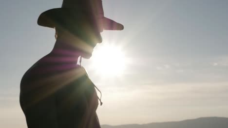 Silhouette-of-a-man-looking-at-the-distance-with-a-hat.-Backlight-slow-motion